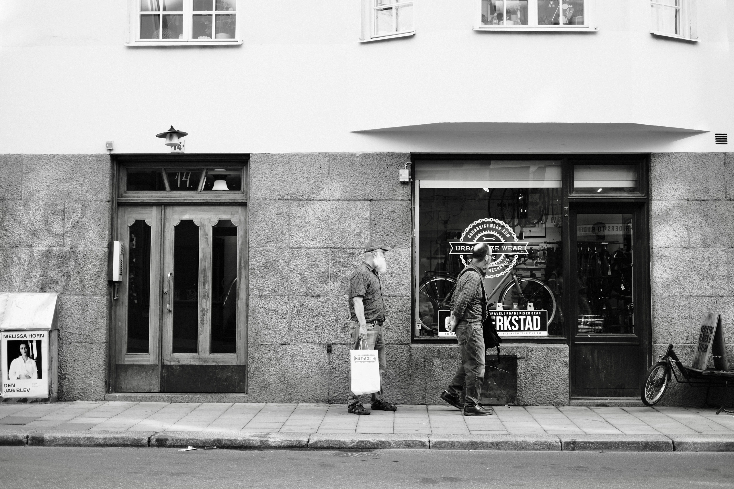 Two people standing outside a street-level shop