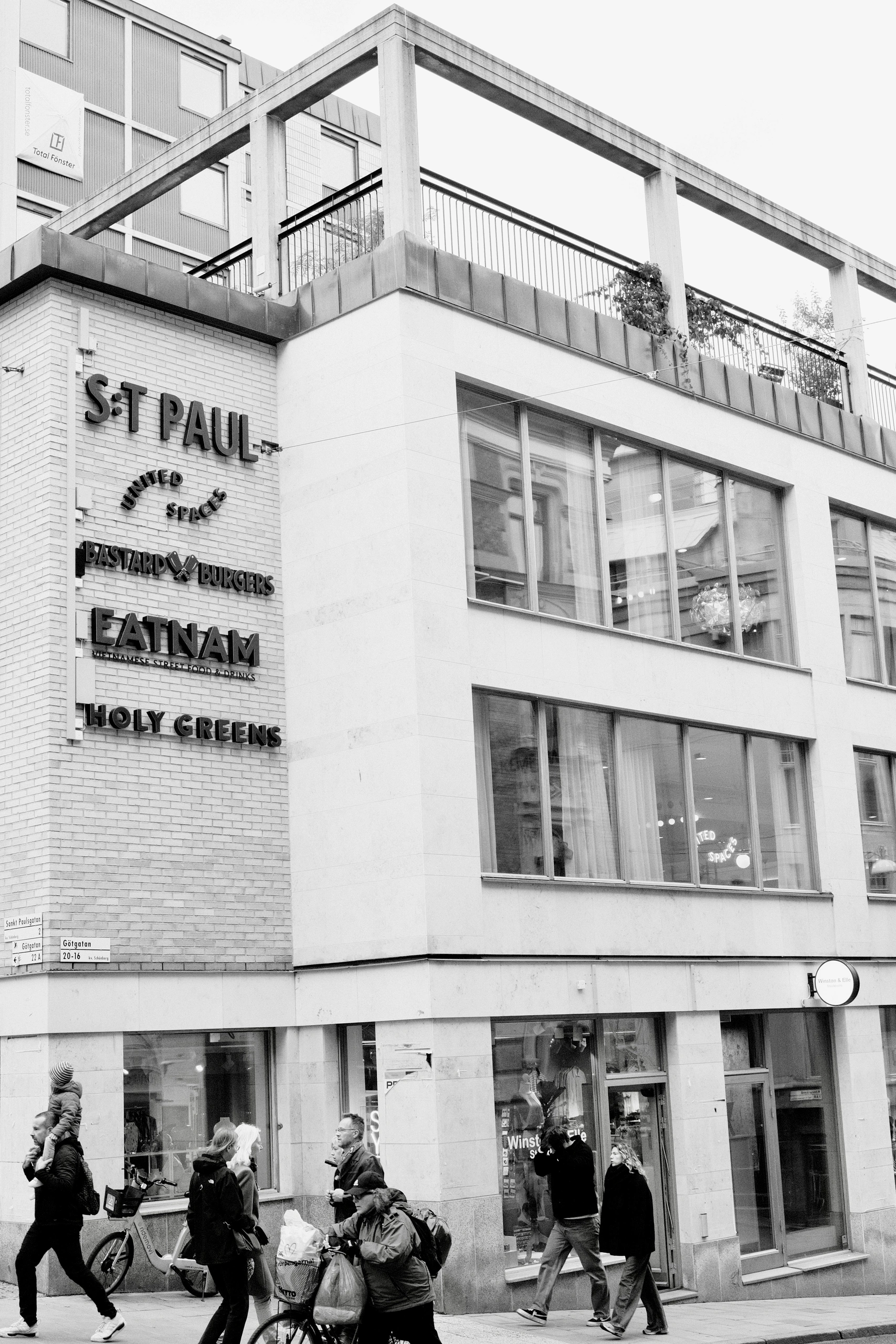 Pedestrians passing a modern corner building